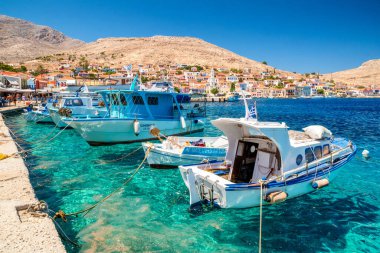 Halki, Yunanistan - 6 Temmuz 2022: Yunanistan 'da limanda balıkçı tekneleri ve Halki Adası' nda (Chalki) renkli evler