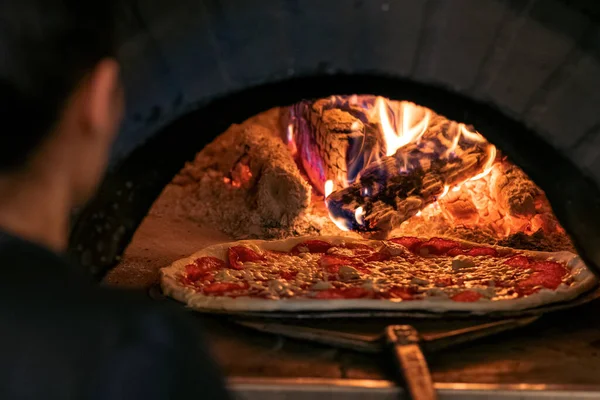 食べ物の概念 伝統的なイタリアのピザを準備する オーブンの前で焼いたピザ — ストック写真