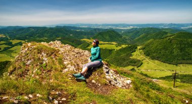 Strazov tepesinde oturan güzel manzaralı bir kız. Slovakya.