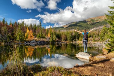 Slovakya 'daki High Tatras dağlarında Rakytovske Pliesko Gölü kıyısında yürüyüş yapan kız..