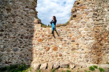 Slovakya 'nın Stranske kasabasındaki St. Helene kilisesinin eski kalıntılarında kitap okuyan bir kız.