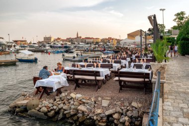 Budva, Karadağ - 24 Ağustos 2023: Karadağ 'ın Budva tatil beldesinde liman terasında yemek yiyen insanlar