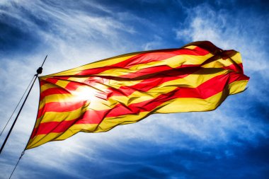 Mavi gökyüzüne karşı Katalonya bayrağı sallıyor..