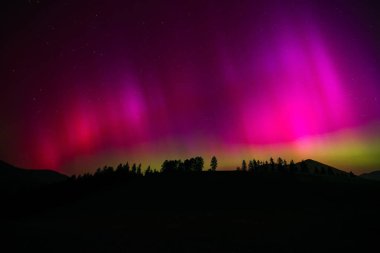 Aurora Borealis, dağların siluetiyle Kuzey Işıkları.