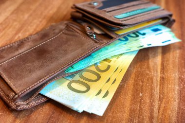 100 ve 200 Euro 'luk banknotları olan kahverengi cüzdan. Satın almalar, işletmeler, finans kavramı.