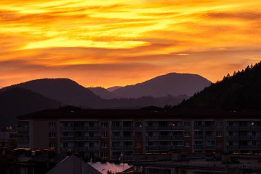 Slovakya 'nın Ruzomberok kasabasında sihirli günbatımında gökyüzünde renkli turuncu bulutlar.