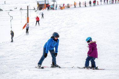 Kayak hocası, çocuklara kış mevsiminde bir kayak merkezinde kayak yapmayı öğretir...