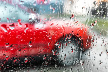 Yağmurlu hava ve yağmur damlaları arabanın camına damlıyor. Dikiz aynasından bak.