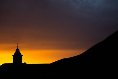 Kilise kulesinin silueti ve arka planda güzel turuncu gökyüzü. İyi akşamlar..