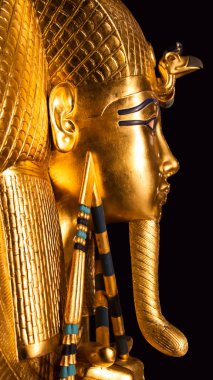 Firavun Tutankamon 'un altın gömme maskesinin dikey yakın çekimi. Eski Mısır sanatı ve siyah arka planda kaliteli altın işçiliği sergileniyor..