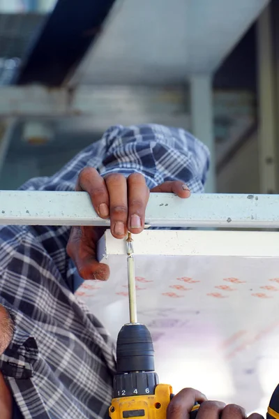 Robotnik Używa Śrubokrętu Elektrycznego Dokręca Śruby Naprawy Pracy — Zdjęcie stockowe