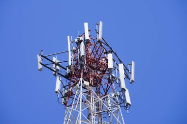 Telekomünikasyon kulesi 4G ve 5G hücresel. Makro Üs İstasyonu. Radyo modüllü ve akıllı antenli 5G radyo ağı telekomünikasyon ekipmanı mavi gökyüzü arkaplanına karşı bir metal üzerine monte edildi.