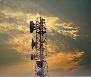 4G ve 5G hücresel. Makro Üs İstasyonu veya Üs Alıcı İstasyonu. Telekomünikasyon kulesi. Kablosuz İletişim Anten Vericisi. Gün batımında kentsel alandaki iletişim sistemlerinin geliştirilmesi.