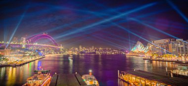 Panorama Vivid Sydney şehri ışıklandırılmış köprüsü, Opera Binası, rıhtım ve aydınlatılmış mimarisi ile geceleyin, Avustralya, 3 Haziran.