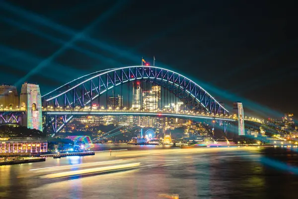 Liman köprüsü ve liman kenti silueti üzerinde renkli Sydney Lazer Gösterisi 3 Haziran 2025 'te Avustralya' da uzun pozlu bir fotoğrafla geceleyin çekildi.