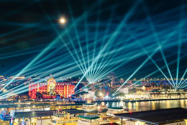 Canlı Sydney lazer ışıkları ve hilal ay gece gökyüzünde renkli ışınlar ve şehir mimarisi manzaralı modern sanat müzesinin üzerinde, Avustralya, 3 Haziran 2025
