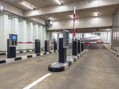 Otoparkın giriş ve çıkışında bariyer var. Otomatik bariyer. Yeraltı otoparkı, garaj. Park yerinin içi