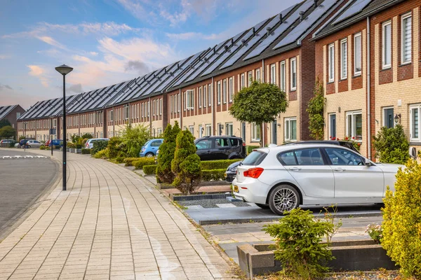 Row of modern houses in curved street. Contemporary neighborhood with solar panels. With gardens and private parking places. Street view in Heerhugowaard, Netherlands.