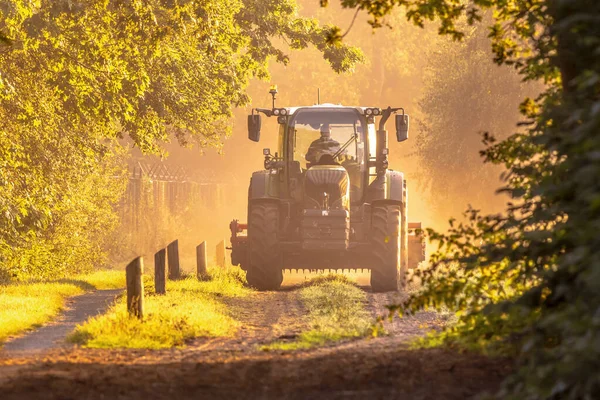 Altın Gün Doğumu Sisli Işıkta Traktör Sabahleyin Toprak Yolda Tarım — Stok fotoğraf