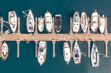 İspanya 'da bir marinada yatlar, yelkenliler ve sürat tekneleri. Akdeniz 'in turkuaz mavi suyunda. Yukarıdan görülen hava görüntüsü.