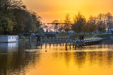 Hollanda, Zwolle, Overijssel 'deki Willemsvaart Kanalı' ndaki yüzen evler ve köprünün üzerinde gün batımı. Avrupa 'nın manzara manzarası..
