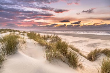 Hollanda 'nın Ameland adasından Kuzey Denizi üzerindeki kum tepesinden gün batımı görüntüsü