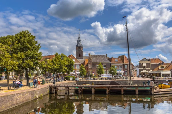 stock image BLOKZIJL, THE NETHERLANDS - JULY 13, 2017: Harbor in the historic village of Blokzijl on sunny summer day with old flat bottom ships and monumental houses and church, Netherlands