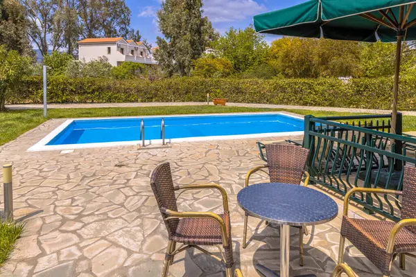 Swimming pool at holiday Bungalow with furniture on summer vacation in Greece.