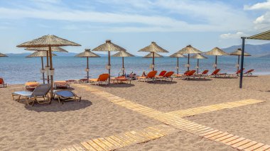 Yunanistan 'ın Lezbiyen Adası' ndaki bir plajda şemsiyeyle dolaşmış. Yunan adasının plajından hoş bir manzara. Avrupa