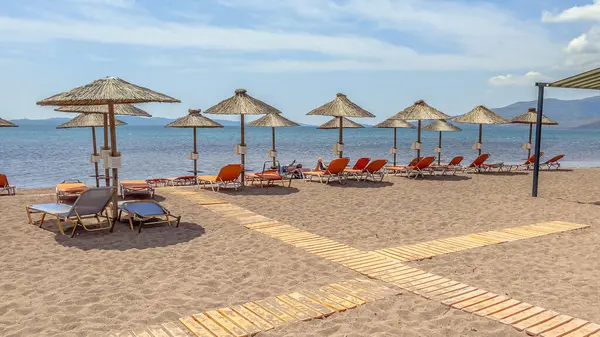 Yunanistan 'ın Lezbiyen Adası' ndaki bir plajda şemsiyeyle dolaşmış. Yunan adasının plajından hoş bir manzara. Avrupa