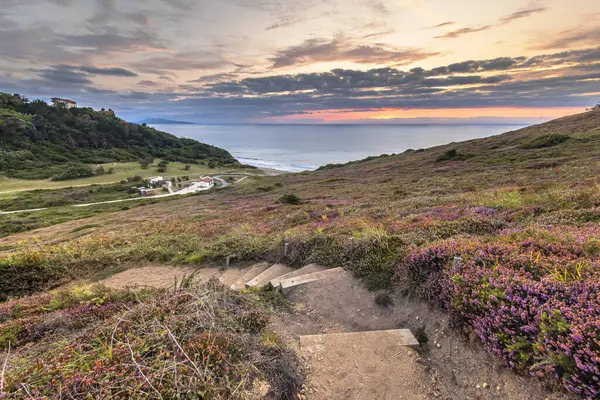 Erretegia Körfezi 'nde gün batımı. Belvedere de Bidart 'ta, Fransız Bask sahilinde bir sahil. Doğal bitki örtüsünde merdivenlerle yürüme pisti. Biarritz, Biscay Körfezi, Fransa. Avrupa 'da Doğa Manzarası.