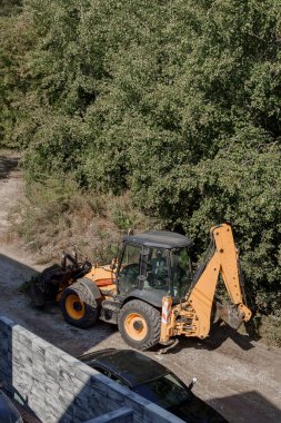 Turuncu bir traktör, Polonya, Marki 'den kalan kumları topluyor..