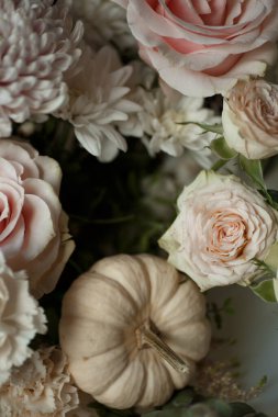 Pastel pembe güller, beyaz kasımpatılar ve küçük bir bej balkabağı manzarası. Romantik çiçek kompozisyonu sonbahar düğün davetiyeleri, mevsimlik tebrik kartları ya da markalaşma için mükemmel..