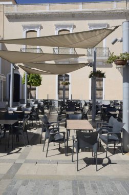 Moguer, İspanya - 30 Temmuz 2023: İspanya 'nın Huelva kentindeki Endülüs köyü Moguer meydanında bulunan boş bir bar terası.