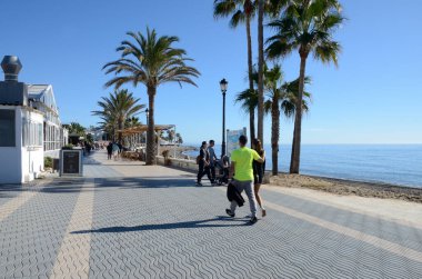 Marbella, İspanya - 10 Aralık 2023: Marbella, Endülüs, İspanya 'da Akdeniz kıyısındaki gezinti güvertesinde az sayıda insan.