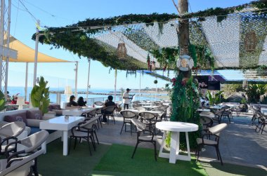 Marbella, İspanya - 10 Aralık 2023: İnsanlar İspanya 'nın Marbella kentindeki Banus Limanı' ndaki pitoresk restoran terasında yemek yiyorlar.