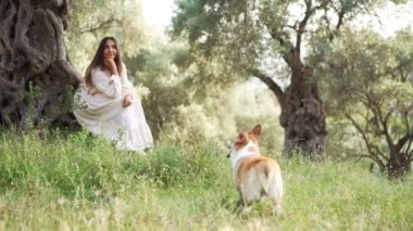 Bir kadın, neşeli bir köpek olan Galli Corgi Pembroke ile oynamanın keyfini çıkarırken huzurlu bir an başlıyor.