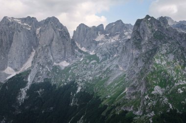 Dağlık arazinin enginliği, yemyeşil vadilerle ve yumuşak bir gökyüzünün altında engebeli tepelerle gözler önüne seriliyor.