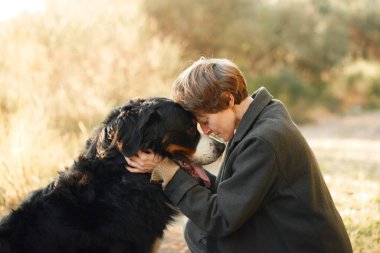 Bir kadın, Bernese Dağ Köpeği 'yle sevgi dolu bir şekilde etkileşime girer..