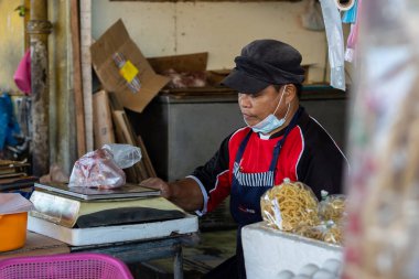 Kota Kinabalu, Sabah, Malezya - 7 Ağustos 2021: Pandemic Covid-19 sırasında yerel malzemelerde yüz maskesi takan alıcının ve satıcının resmi