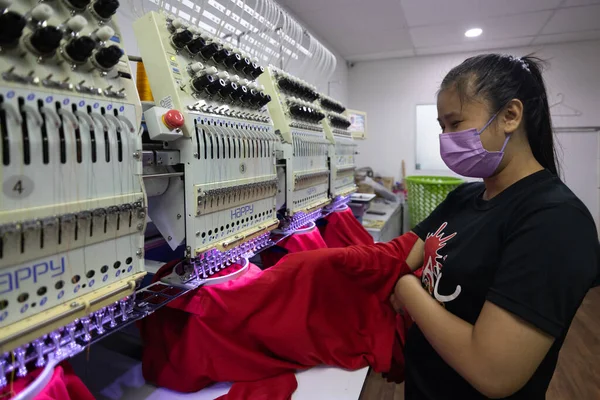 コタキナバル マレーシア 8月24日 2021年 メディカルフェイスマスクを持つ女性労働者が ガーメント製造の織物産業で刺繍機を運用しています — ストック写真