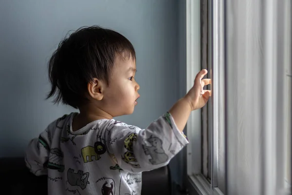cute Asian Chinese 1 years old Asian Chinese baby boy playing around windows.
