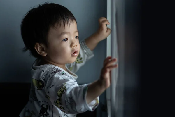 cute Asian Chinese 1 years old Asian Chinese baby boy playing around windows.