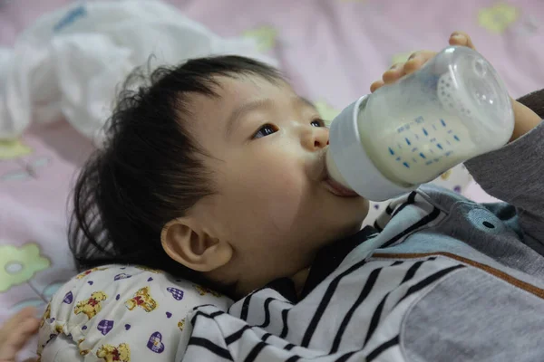 Азиатский Китайский Мальчик Лежит Кровати Бутылкой Молока Пьет Молоко — стоковое фото