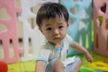 Portrait image of 1 to 2 years old childhood child. Face of relax and happy Asian boy in head shot.