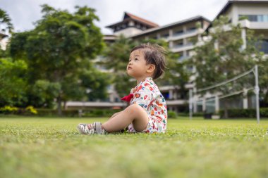Portrait image of Happy 1-2 years old Asian Chinese child enjoying playing on clean green park