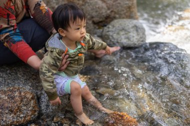 Happy 1-2 years kids enjoying playing clean river water