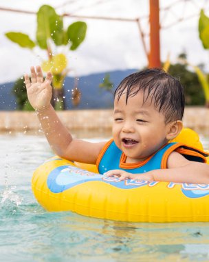 1-2 yaş arası, mutlu ve bilardo oynayan bir çocuğun portresi.