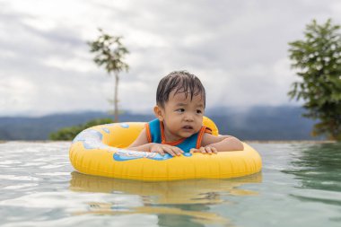 1-2 yaş arası, mutlu ve bilardo oynayan bir çocuğun portresi.