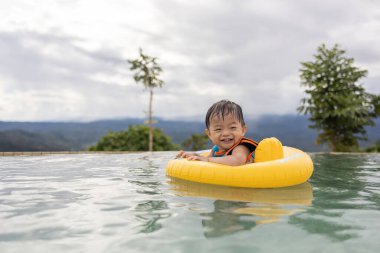 1-2 yaş arası, mutlu ve bilardo oynayan bir çocuğun portresi.